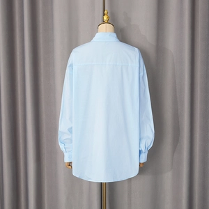 Back view of light blue casual shirt with classic collar and curved hem on a mannequin