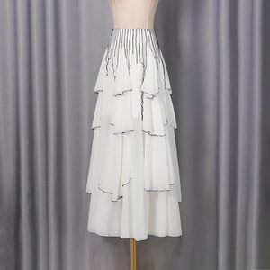 Detailed view of layered white chiffon maxi skirt with elegant black contrast edge trim