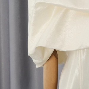 Detailed macro view showing the pearlescent satin fabric and delicate ruffled texture