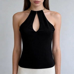 Detail of black halter top featuring gold chain neck strap and drop-shaped chest cutout
