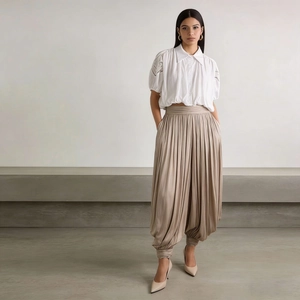 Détail du pantalon lanterne plissé taille haute et du crop top en dentelle sur le mannequin