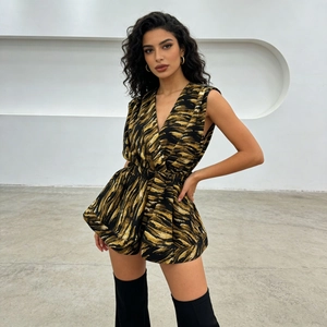 Detail of V-neck sleeveless romper featuring a bold black and gold tiger stripe print