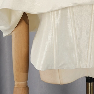 Close-up of pearl white corset top with shimmer fabric and structured boning detail