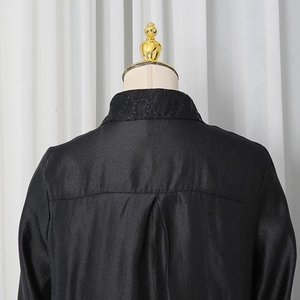 Detailed back view of a black satin shirt featuring sequined collar and pleated shoulders