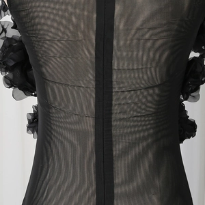 Detailed close-up of sheer mesh jumpsuit with 3D floral accents and hidden back zipper