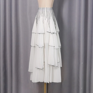 Close-up of high-waist pleated skirt with white mesh layers and black contrast piping edge
