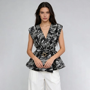 Detail of waist belt with gold round buckle on black and white striped sleeveless top