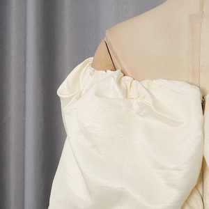 Detailed view of cream off-shoulder corset top with puff sleeves and invisible side zipper