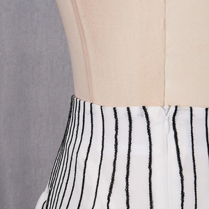 Detail of invisible zipper on high-waisted white mesh skirt with black vertical stripes