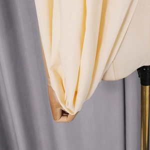 Macro detail of creamy silk-like fabric with natural drape and delicate texture on mannequin