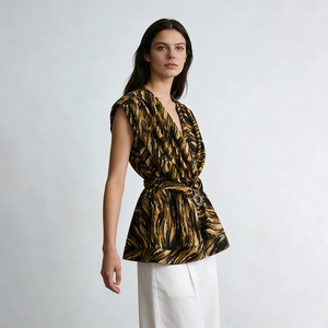 Detail of tiger-print sleeveless top featuring deep V-neck and gold buckle belt