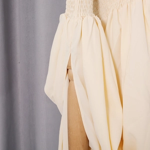 Detailed view of cream lantern sleeves with smocked cuffs and elegant split design