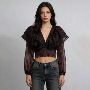 Dettaglio dello scollo a V con volant e maniche in mesh trasparente su crop top floreale