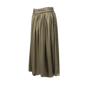 Détail d'une jupe longue en satin vert olive à taille haute avec plis élégants et soyeux