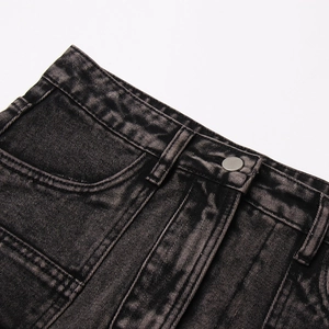 Dettaglio della vita in gonna di denim nero lavato con bottone in metallo