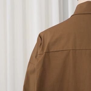 Detailed view of the shoulder yoke and stitching on this brown long-sleeve casual shirt