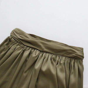 Détail d'une jupe en satin vert olive avec taille torsadée et texture plissée fine