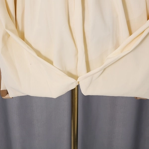 Detail shot of the cream twist waist design and high-quality woven fabric texture