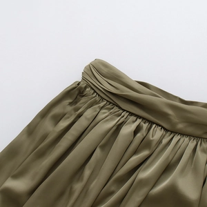 Détail de la taille haute plissée et de la texture soyeuse du satin vert olive
