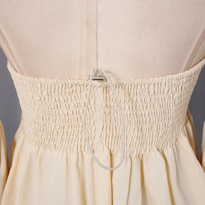 Detail of off-white top featuring elastic shirred texture and silver drawstring adjuster