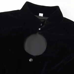 Detail view of a black velvet jacket featuring a Mandarin collar and a hollow-out neckline