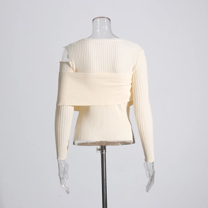 Detail of off-white ribbed knit sweater showing cold-shoulder cut and layered texture