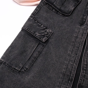 Dettaglio della gonna cargo in denim grigio scuro con grande tasca a patta e trama lavata