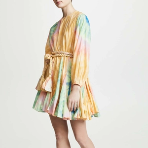 Détail d'une robe tie-dye à manches longues avec ceinture tressée et détails de glands