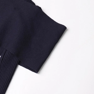 Close-up of dark navy knit sweater showing rib-knit cuff details and fine fabric texture