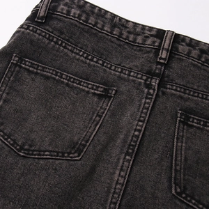 Dettaglio delle tasche posteriori e doppie cuciture su gonna in denim nero lavato