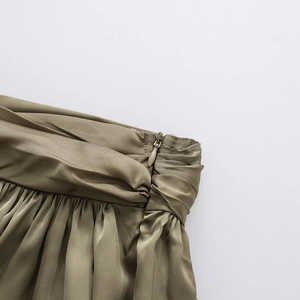 Détail de jupe en satin vert olive avec fermeture éclair invisible et taille plissée