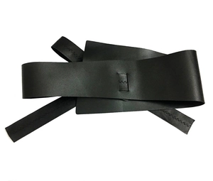 Détails des coutures en zigzag sur une large ceinture obi noire en similicuir avec liens