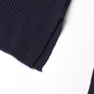 Close-up of navy blue knit sweater featuring ribbed texture and side slit detail