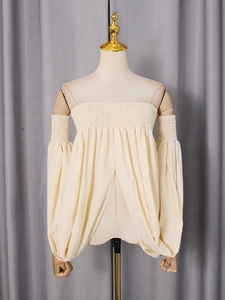 Beige off-shoulder smocked top with elegant puff sleeves and textured fabric