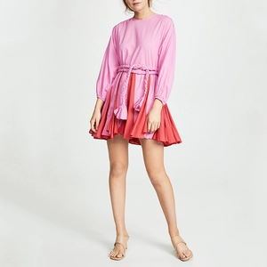 Détail de la robe trapèze plissée rose et rouge avec ceinture tressée et franges