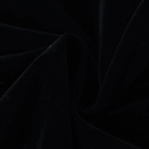 Macro shot of premium black velvet fabric texture with soft sheen and elegant draped folds