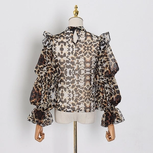 Detailed close-up of leopard print chiffon fabric with ruffled collar and lantern sleeves