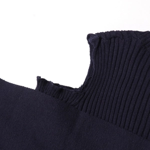 Detail of navy knit sweater showing rib texture and delicate ruffled edge craftsmanship