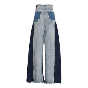 Detail of high waist patchwork denim jeans featuring distressed raw edges and wide leg cut
