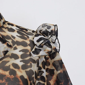 Detailed view of leopard print chiffon fabric with ruffled edges and black stitching