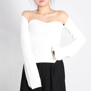 Detail of white rib-knit fabric and irregular split hem of this off-shoulder sweater