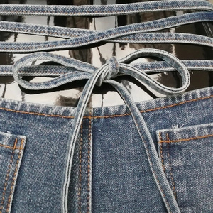 Detaillierte Makroansicht der Jeans-Hotpants mit Schnürung an der Taille und Ziernähten