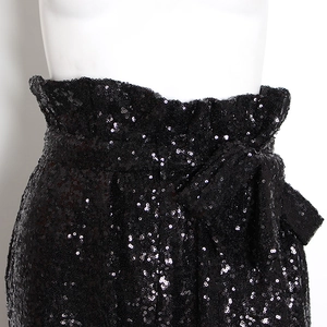 Dettaglio ravvicinato dei pantaloni con paillettes a vita alta, fascia elastica e fiocco