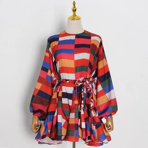 Détail d'une robe à imprimé géométrique avec manches lanternes et ceinture tissée