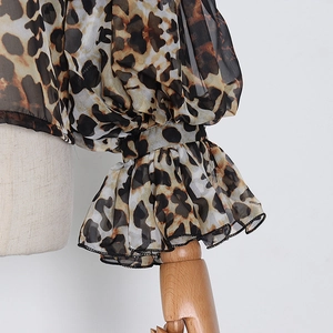 Detail of leopard print sheer chiffon top showing puff lantern sleeves with ruffled cuffs