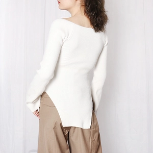 Detail view of the ribbed knit top featuring a unique asymmetric side split hem design