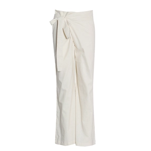 Détail du pantalon large taille haute crème avec nœud papillon et texture du tissu coton