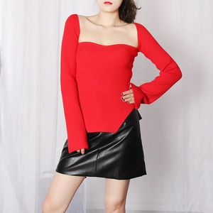 Detail view of red square neck ribbed knit sweater with side slits and black leather skirt