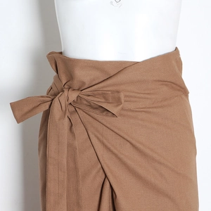 Détail de la taille haute avec nœud et tissu texturé sur le pantalon large camel