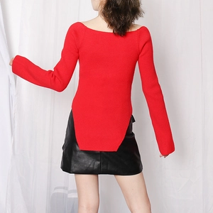 Detail view of the irregular long back hem on this red ribbed knit sweater top